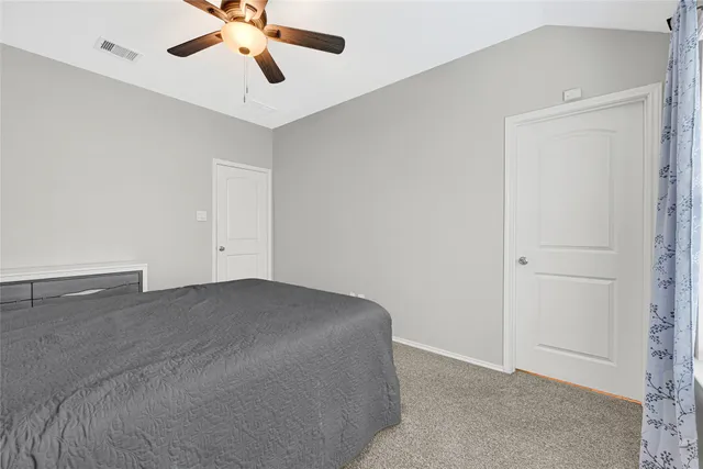 a view of a room with a ceiling fan and hardwood floor
