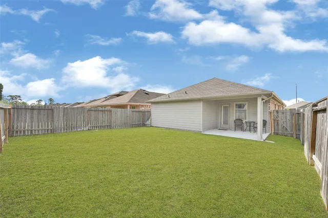 a view of a house with a yard and a large tree