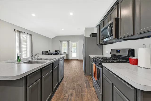 a kitchen with stainless steel appliances granite countertop a sink stove and cabinets