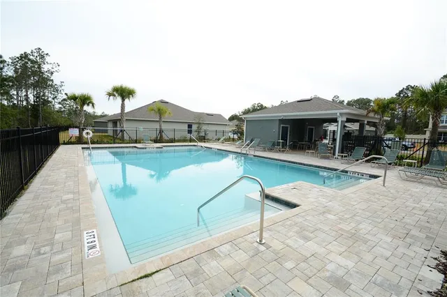 swimming pool view with a seating space and a garden view