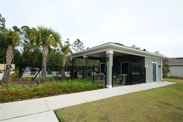 a view of backyard with swimming pool and seating space