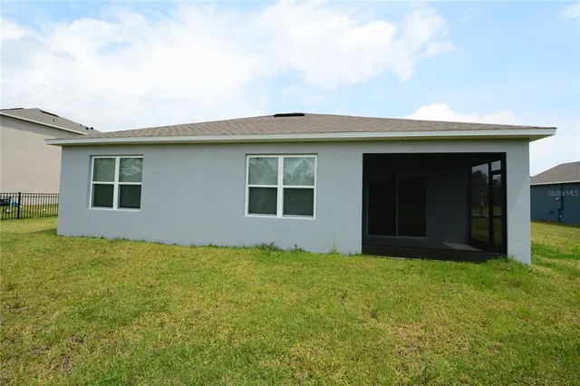 a view of an house with backyard space and windows