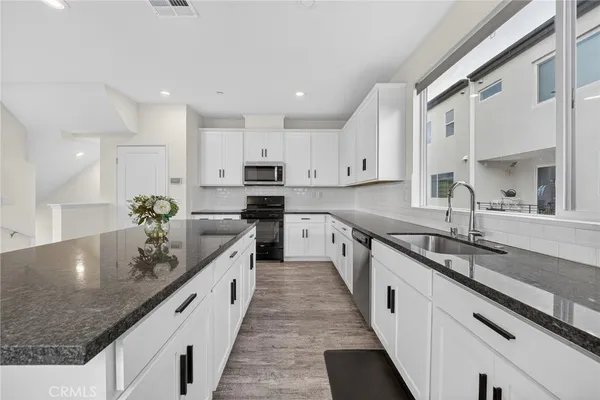 a kitchen with stainless steel appliances granite countertop a sink and cabinets