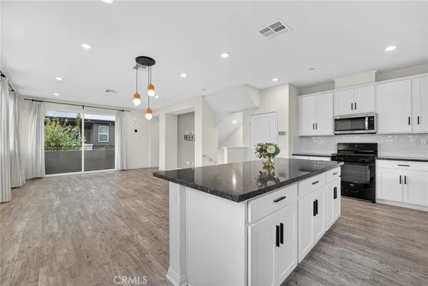 a kitchen with white cabinets and black appliances