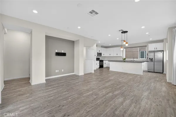 a view of kitchen with wooden floor and stainless steel appliances