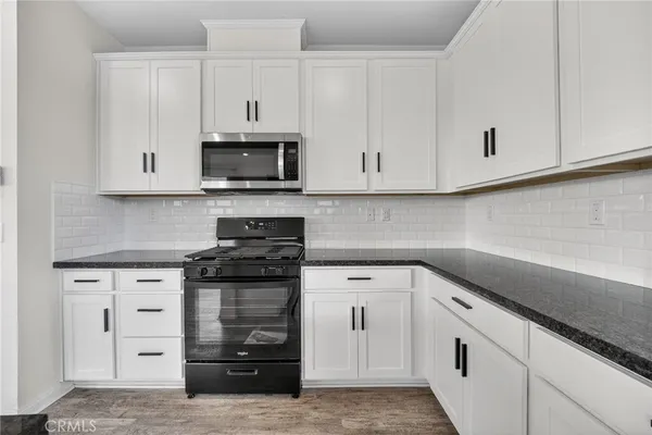 a kitchen with granite countertop white cabinets and sink