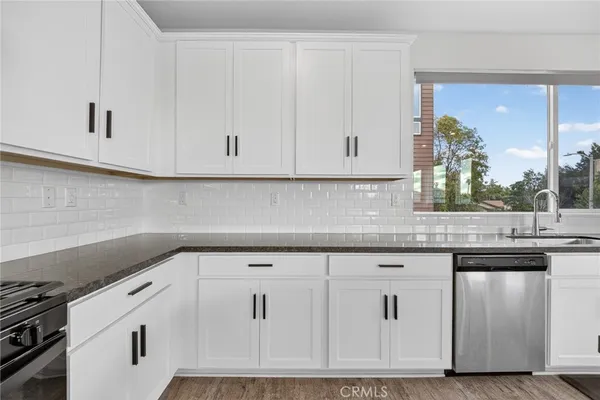 a kitchen with a refrigerator and white cabinets