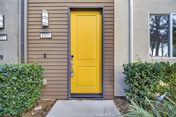 a front view of a multi story residential apartment building with yard and parking