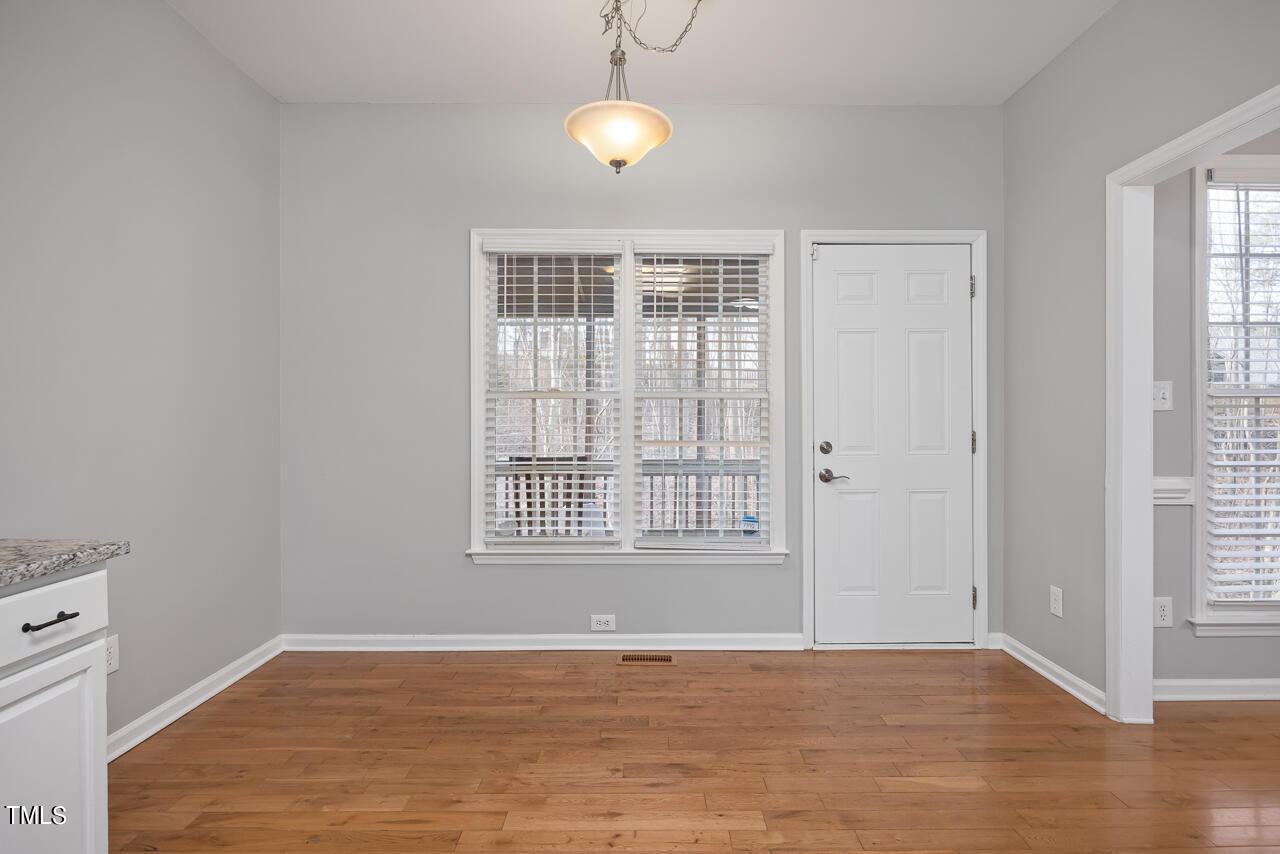 6921 Lamarsh Court Raleigh, NC 27617 - Photo 13 of 37 a view of an empty room with wooden floor and a window