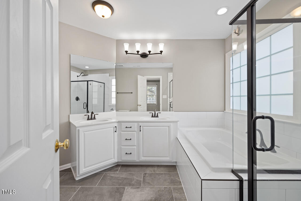 6921 Lamarsh Court Raleigh, NC 27617 - Photo 18 of 37 a spacious bathroom with a bathtub shower sink and mirror