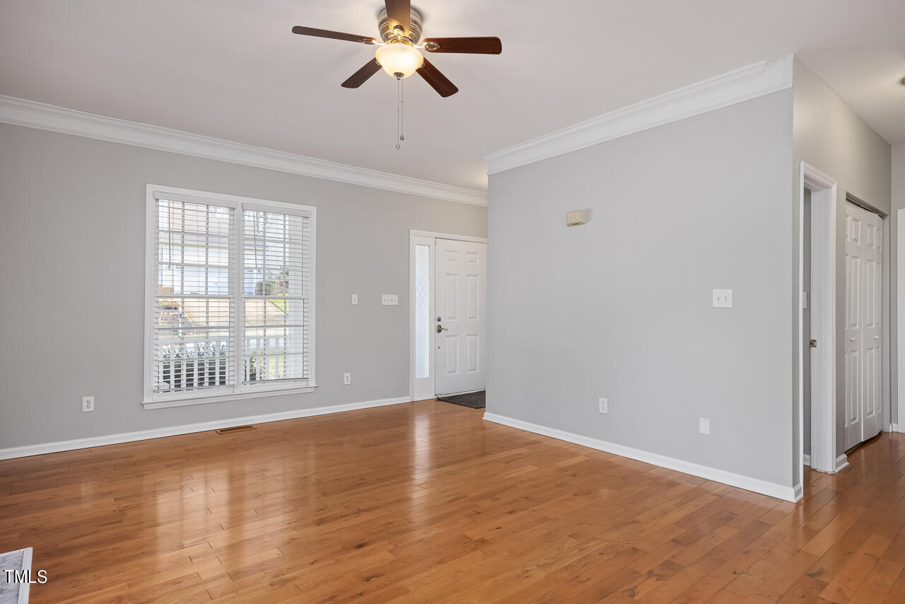6921 Lamarsh Court Raleigh, NC 27617 - Photo 4 of 37 an empty room with wooden floor fan and windows