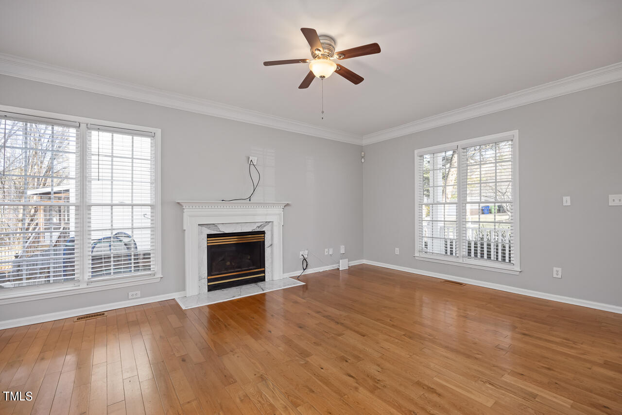 6921 Lamarsh Court Raleigh, NC 27617 - Photo 6 of 37 wooden floor fireplace and windows in an empty room