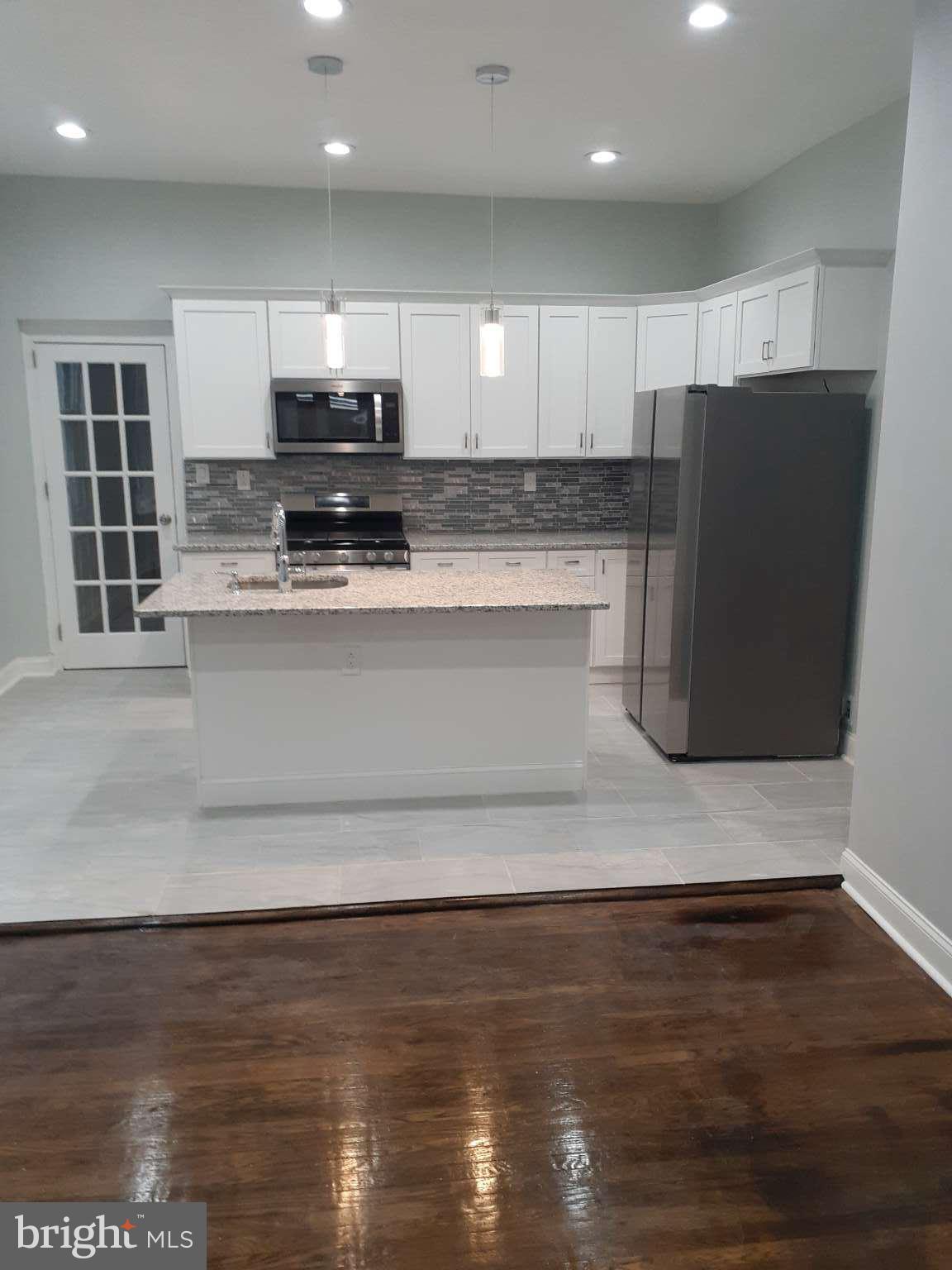 a view of kitchen with granite countertop stainless steel appliances counter space and a sink