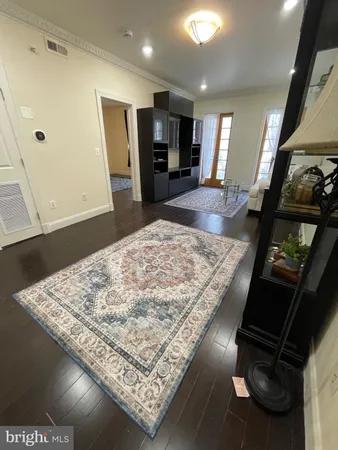 a living room with hard wood floors and a rug