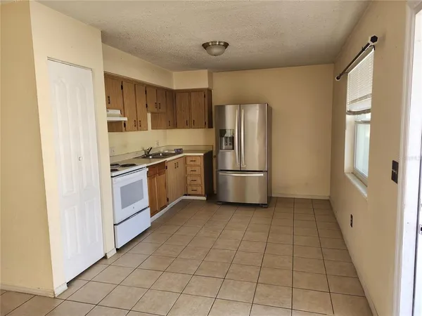 a kitchen with granite countertop a refrigerator and a stove top oven