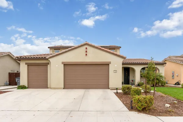 a view of a white house with a yard and plants