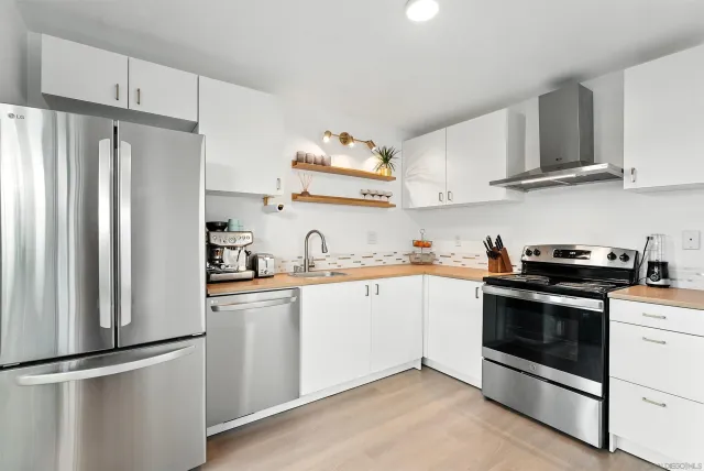 a kitchen with stainless steel appliances granite countertop a refrigerator sink and stove