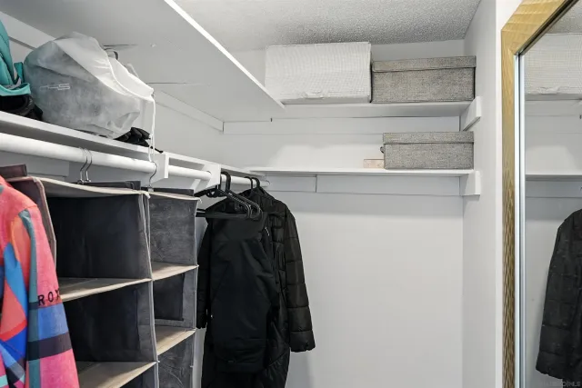 a view of walk in closet with clothes and shoes