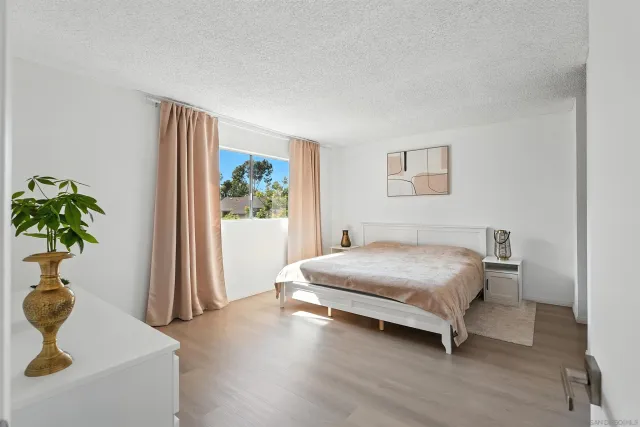 a bedroom with a bed and a potted plant