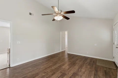 an empty room with a window and a ceiling fan