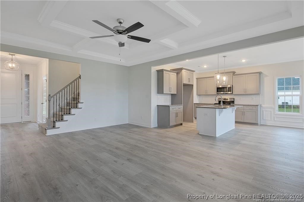 6732 Sim Canady Road Hope Mills, NC 28348 - Photo 4 of 5 a view of an empty room with wooden floor and a ceiling fan