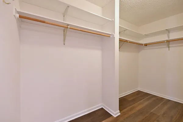 a view of walk in closet with empty racks