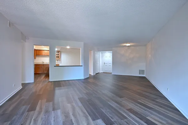 a view of empty room with wooden floor