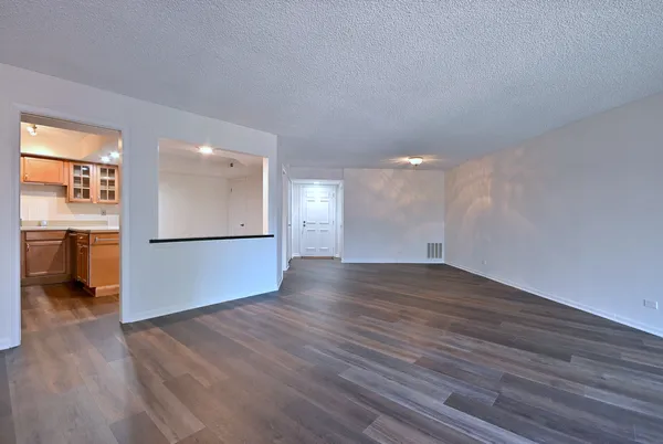 a view of empty room with wooden floor