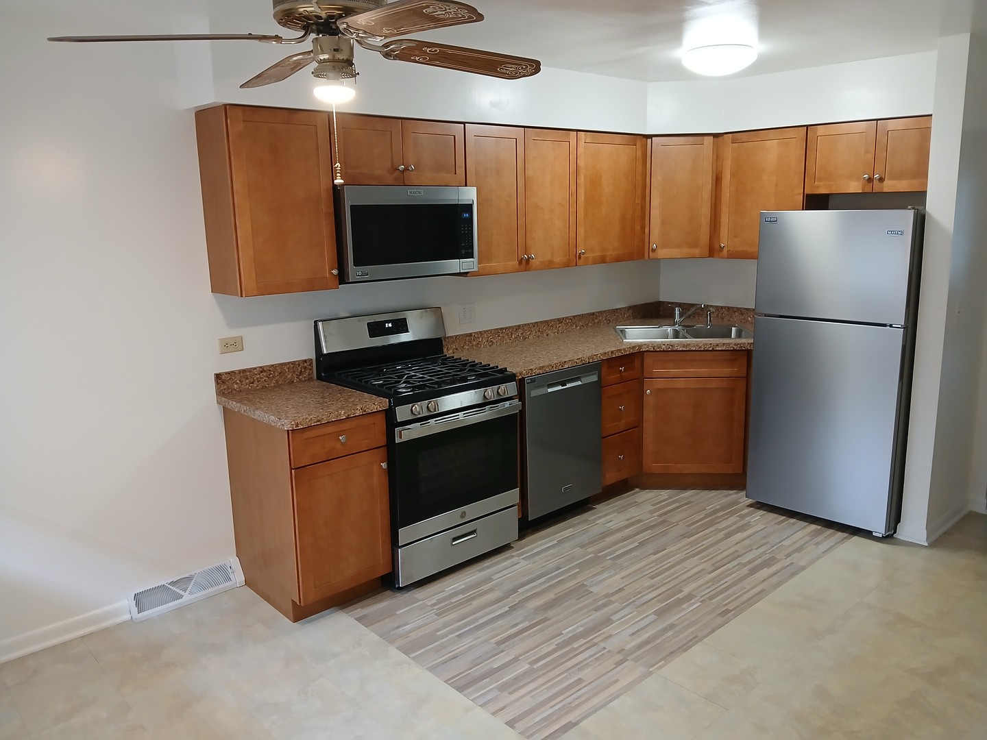 211 North Bothwell Street, Unit 1A Palatine, IL 60067 - Photo 2 of 5 a kitchen with stainless steel appliances a stove a microwave a sink and a refrigerator