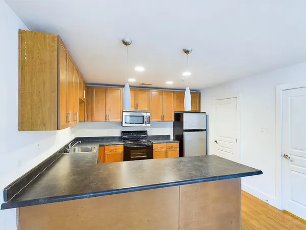 a kitchen with stainless steel appliances granite countertop a sink a stove and a refrigerator