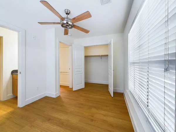 a view of a livingroom with wooden floor and a ceiling fan