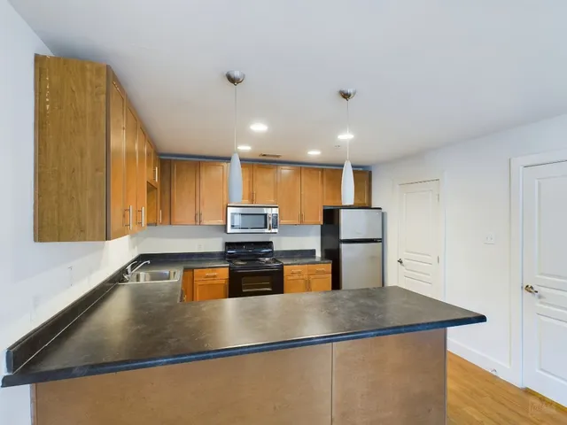a kitchen with stainless steel appliances granite countertop a sink a stove and a refrigerator