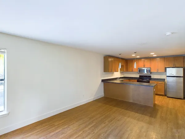 a kitchen with stainless steel appliances granite countertop a stove a sink and a refrigerator