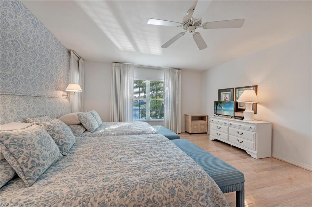 3574 Midas Place Naples, FL 34105 - Photo 15 of 29 a spacious bedroom with a large bed and a chandelier fan
