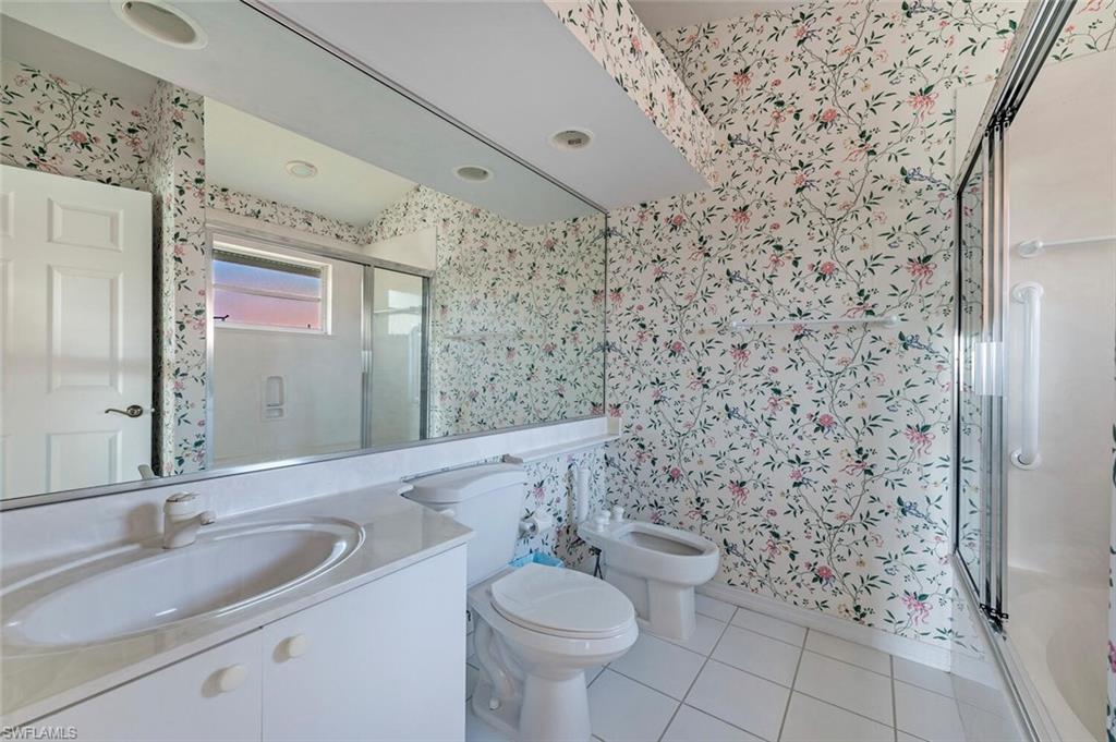 3574 Midas Place Naples, FL 34105 - Photo 20 of 29 a bathroom with a granite countertop toilet a sink and a mirror