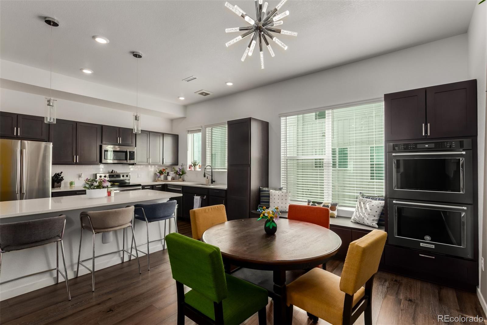 6767 Quivas Way Denver, CO 80221 - Photo 11 of 30 a kitchen with sink refrigerator dining table and chairs