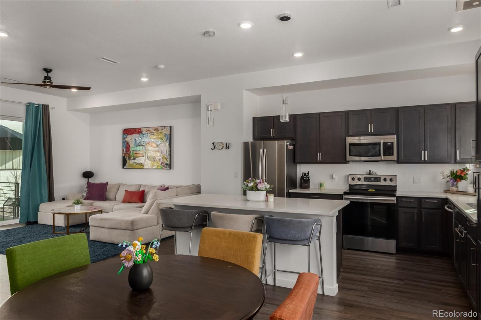 6767 Quivas Way Denver, CO 80221 - Photo 13 of 30 a living room with stainless steel appliances furniture a dining table and kitchen view