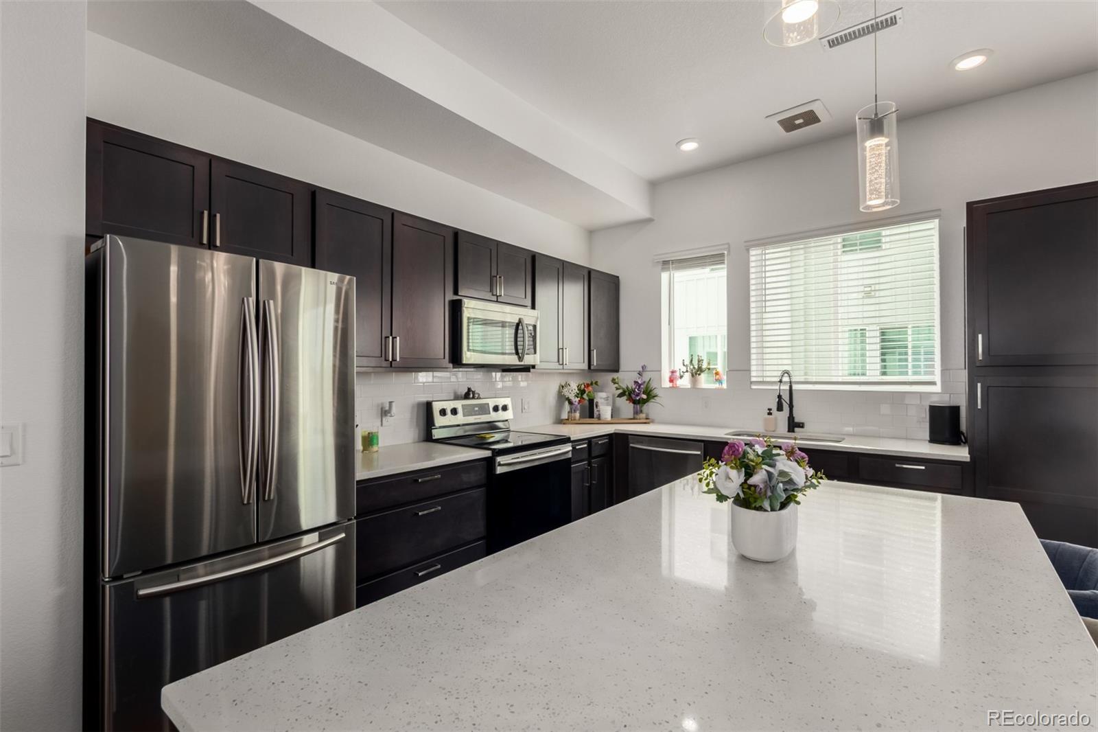 6767 Quivas Way Denver, CO 80221 - Photo 15 of 30 a kitchen with a refrigerator and a stove