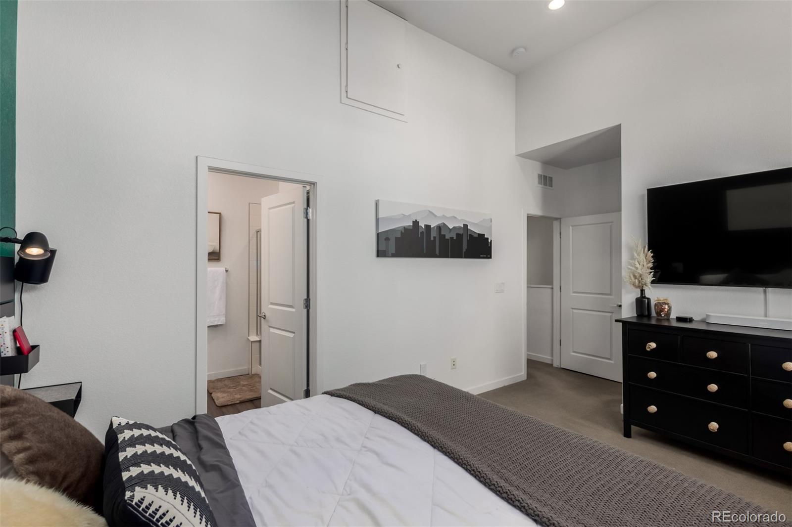 6767 Quivas Way Denver, CO 80221 - Photo 18 of 30 a bedroom with a bed and a flat screen tv