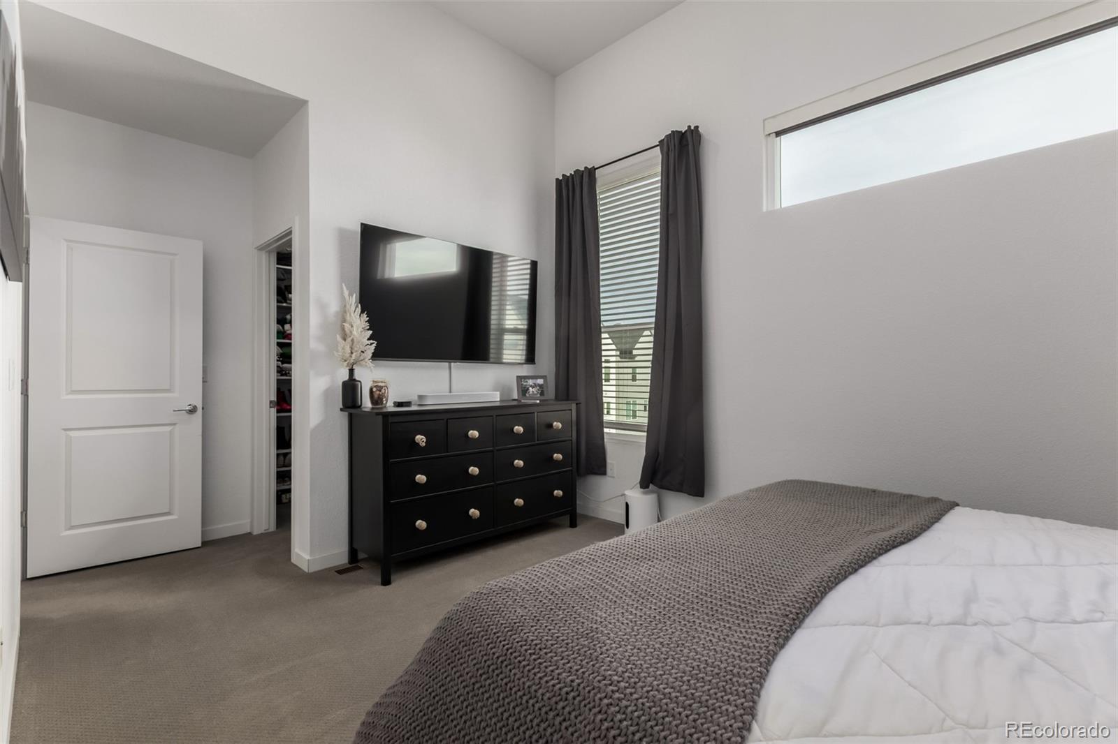 6767 Quivas Way Denver, CO 80221 - Photo 20 of 30 a bedroom with a bed and a flat tv screen on dresser