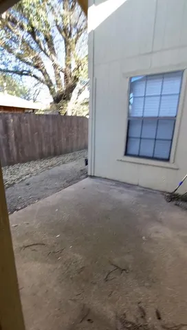 a view of a yard with wooden fence