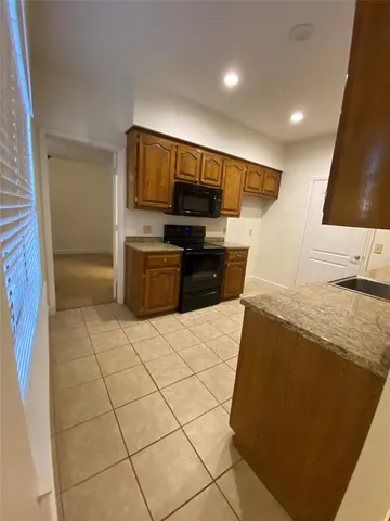 a kitchen with granite countertop a stove a microwave and a sink