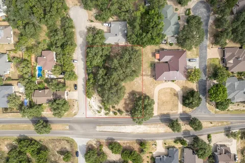 an aerial view of a house with a yard and large tree
