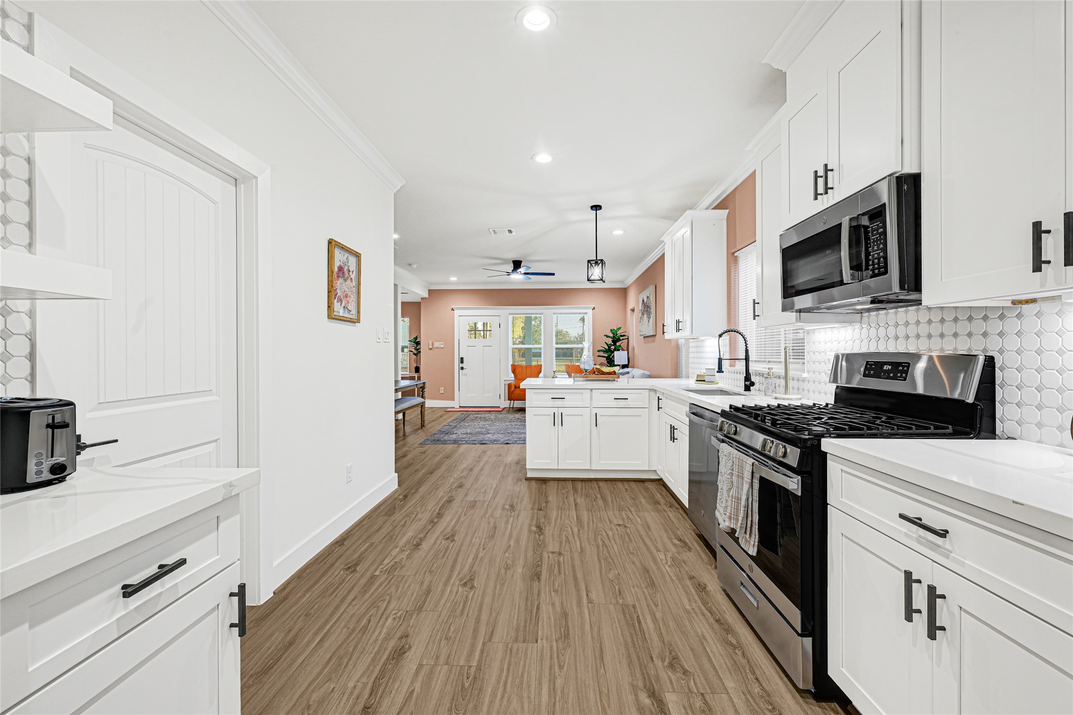 3845 Lydia Street Houston, TX 77021 - Photo 7 of 45 a kitchen with stainless steel appliances a white stove top oven a sink dishwasher and a refrigerator with wooden floor