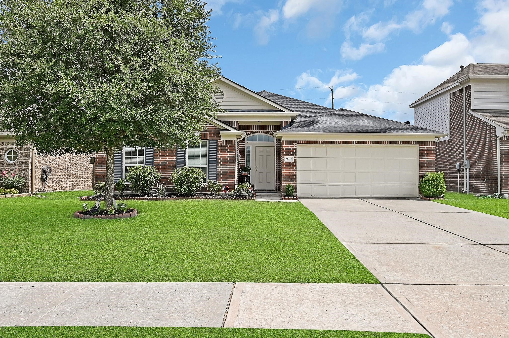 9920 Climbing Tree Street Conroe, TX 77385 - Photo 1 of 19 a front view of a house with a garden