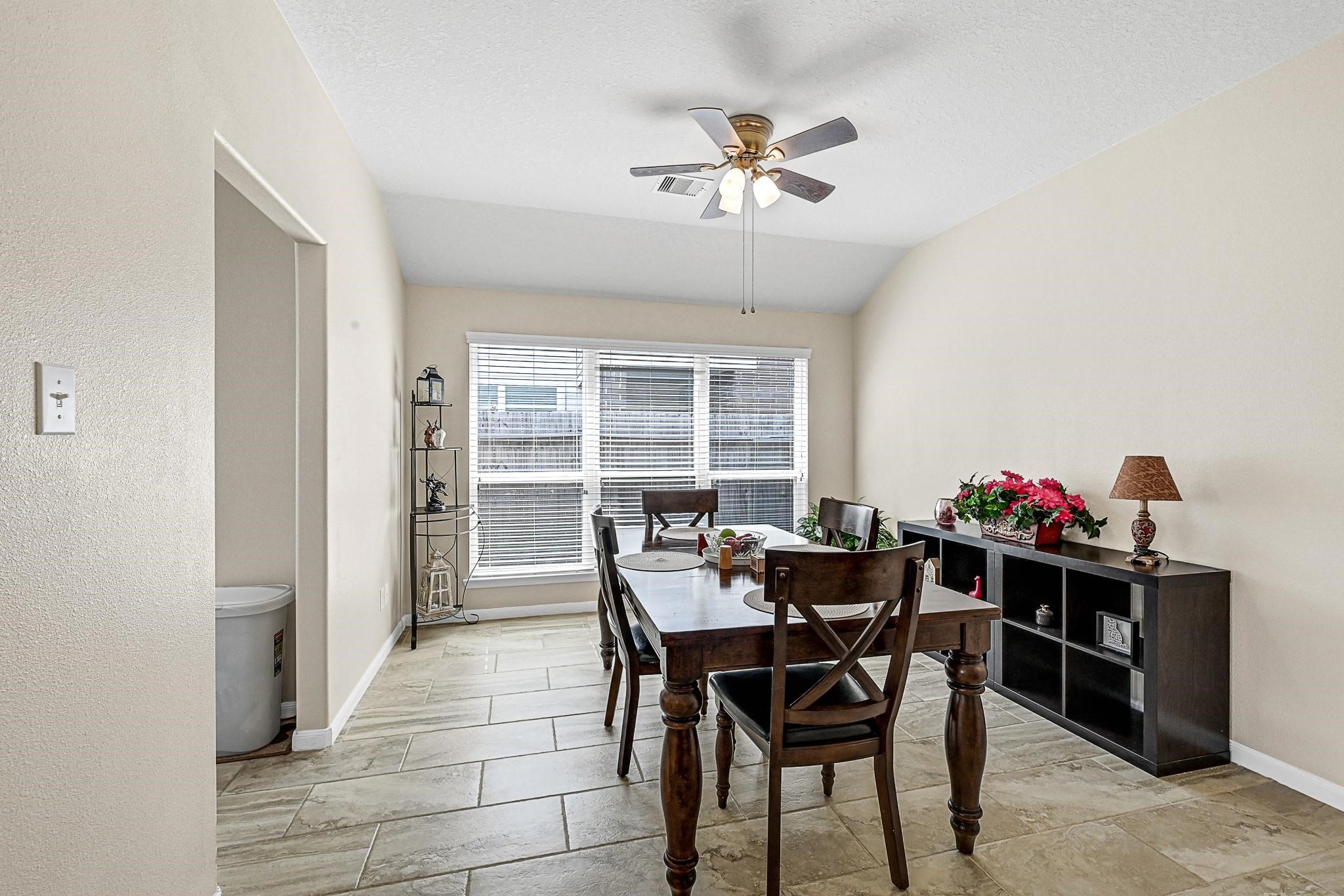 9920 Climbing Tree Street Conroe, TX 77385 - Photo 11 of 19 a view of a dining room with furniture and a chandelier