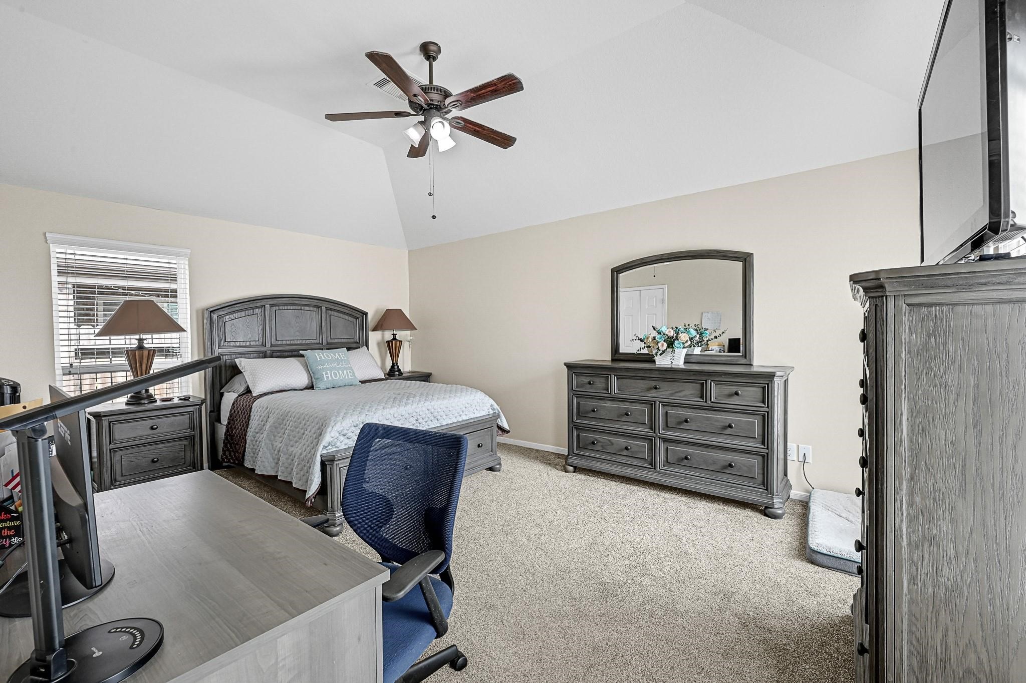 9920 Climbing Tree Street Conroe, TX 77385 - Photo 12 of 19 a bedroom with a bed and dresser with mirror