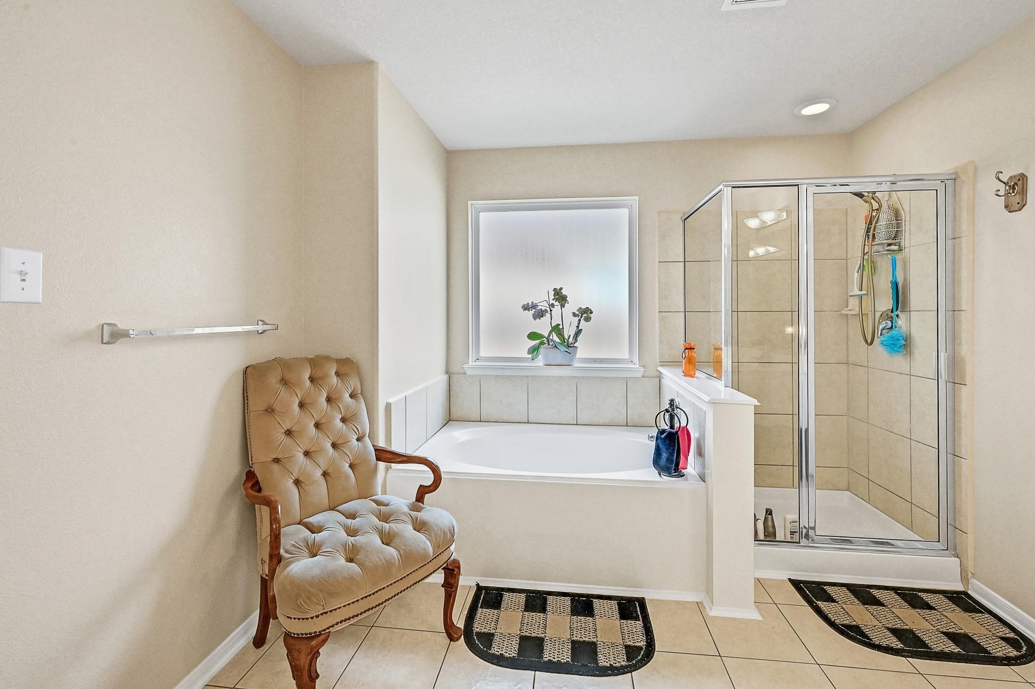 9920 Climbing Tree Street Conroe, TX 77385 - Photo 14 of 19 a bathroom with a bathtub and a shower