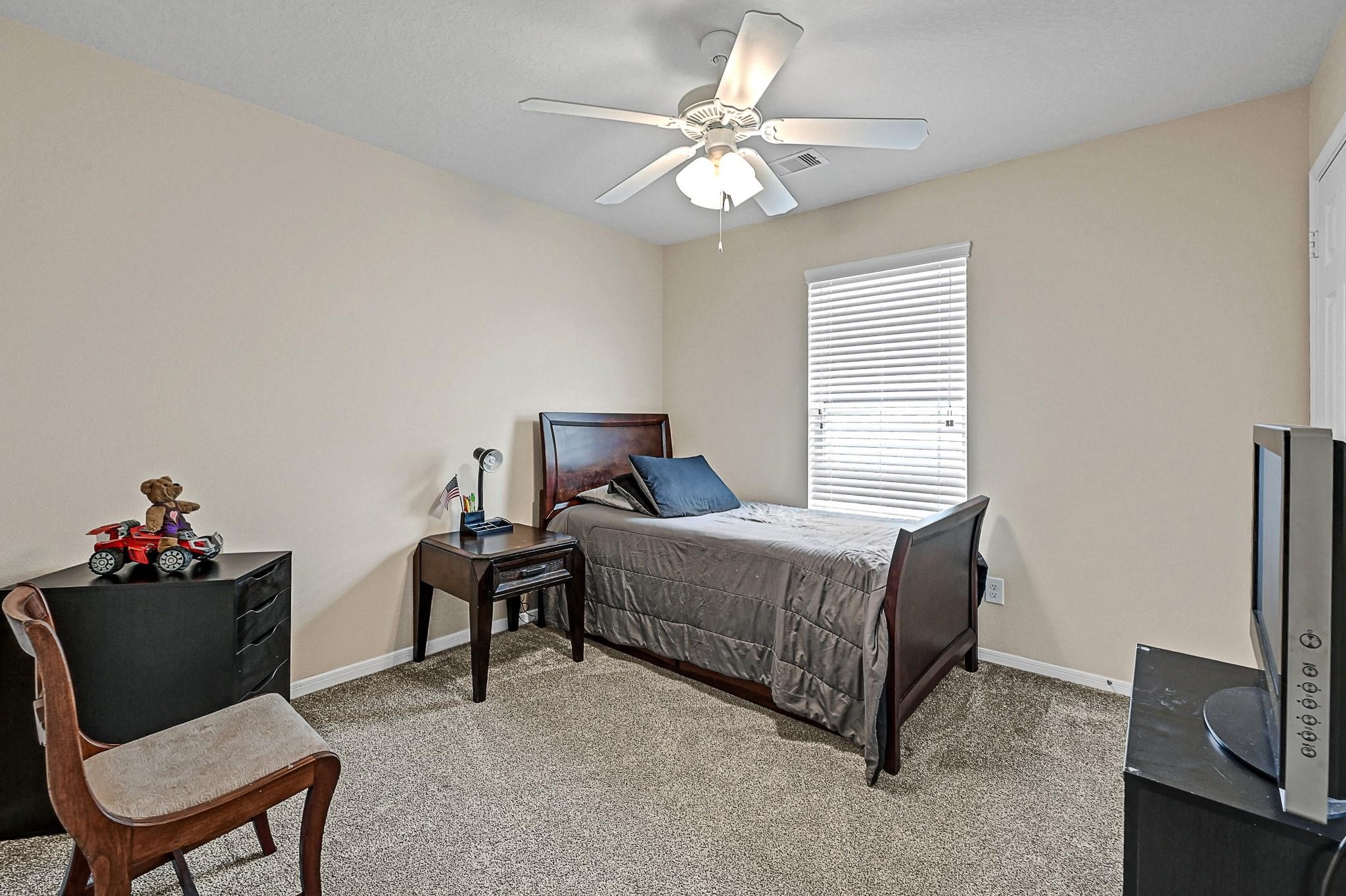 9920 Climbing Tree Street Conroe, TX 77385 - Photo 16 of 19 a living room with furniture and a chandelier