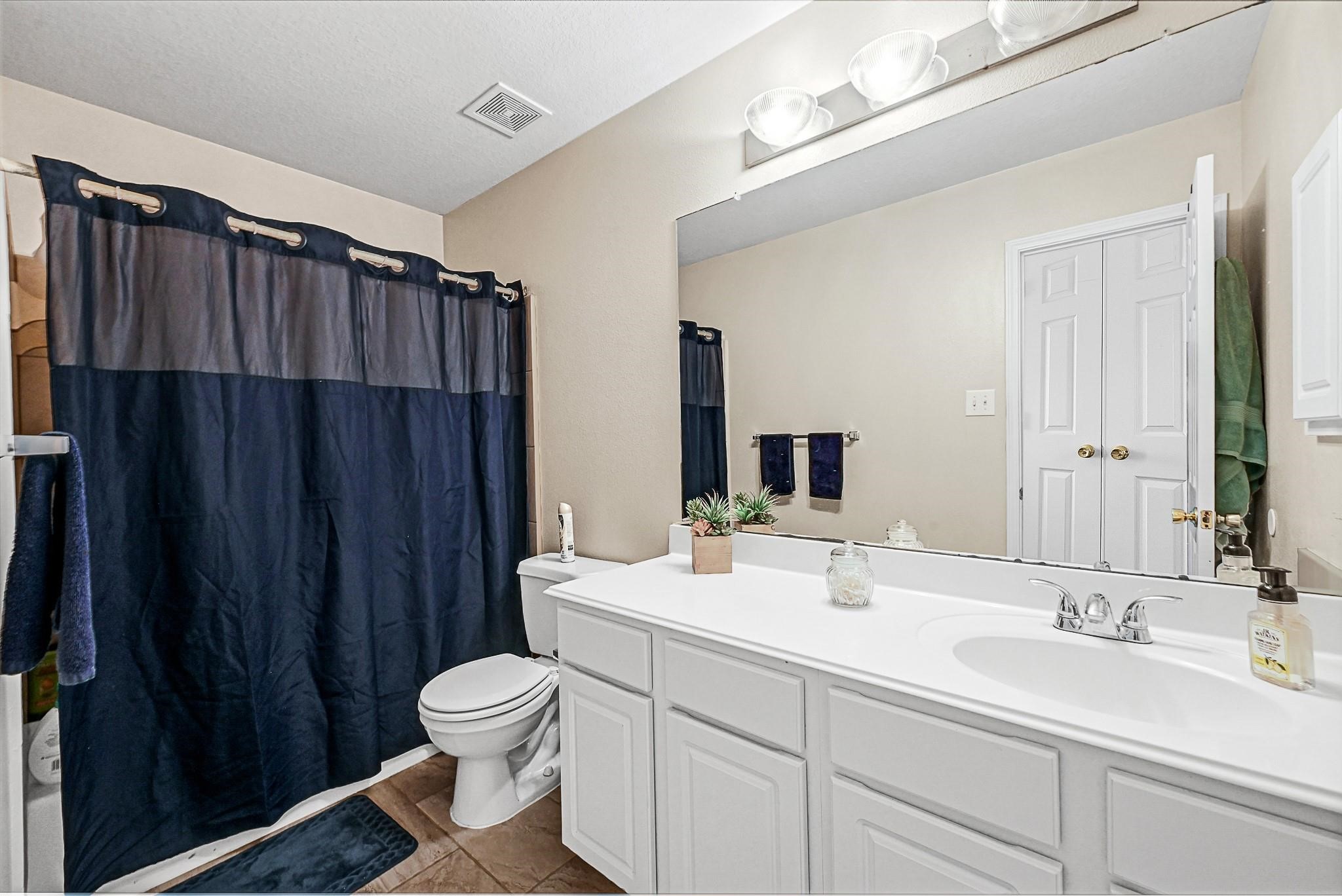 9920 Climbing Tree Street Conroe, TX 77385 - Photo 17 of 19 a bathroom with a double vanity sink toilet and a mirror